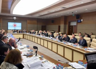 Oyun Yasası Komisyondan Geçti: Kapatma Yetkisi Kalktı, Bant Daraltma Oranları Düşürüldü TBMM Komisyon salonunda, ön plandaki ahşap masada açık duran bir dizüstü bilgisayar ve yanında bir not kağıdı ile kalem. Bilgisayar ekranında oyun platformu arayüzü görünüyor. Arka planda, duvarda asılı büyük Türk bayrağı ve toplantı düzeninde yer alan kırmızı koltuklar, loş ve doğal bir ışıklandırmayla, ciddi bir toplantı sonrası atmosferini yansıtıyor.